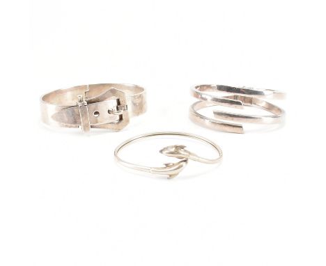 A group of three 925 silver bracelet bangles. The lot to include; a torque crossover bangle with dolphin finials, a hinged be
