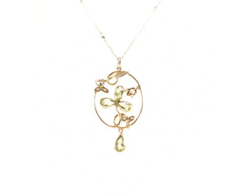 An early 20th Century Edwardian gold peridot and seed pearl pendant necklace. The pendant having a fine link chain with threa