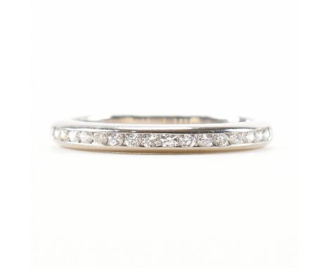 A hallmarked 950 platinum &amp; diamond half eternity ring. The ring having a row of channel set round cut diamonds to a stra