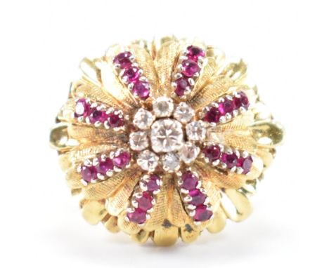 A vintage mid Century 18ct gold diamond and ruby cluster ring. The ring having a floral head set with a central cluster of ro