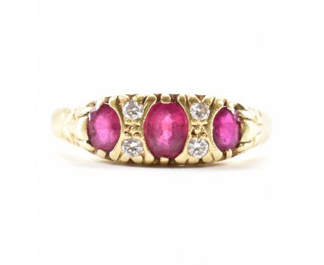 A hallmarked 18ct gold ruby and diamond ring. The ring set with three graduating rubies flanked by round brilliant cut diamon