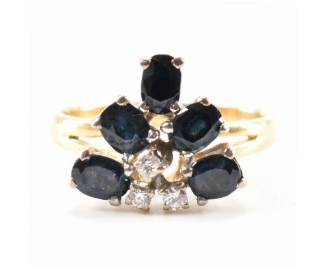 A hallmarked 18ct yellow gold, sapphire &amp; diamond ring. The ring having a stepped trilliant shape head set with three rou