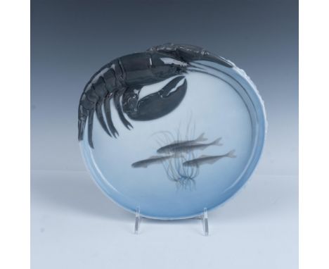 A delightful vintage glossy porcelain dish featuring a lobster mounted along the rim, adorned with fish swimming through seaw