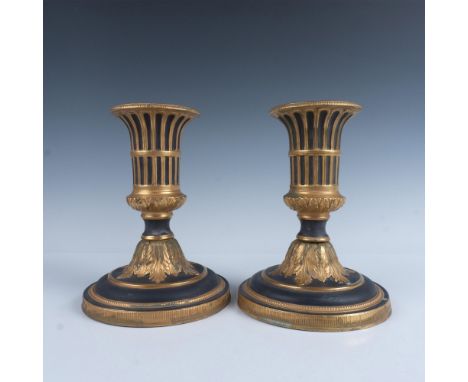 An elegant pair of vintage ceramic candle holders featuring black coloration with ornate gilded detailing. Italy sticker unde