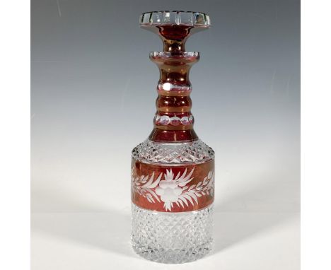 A stunning ruby red cut glass decanter featuring a lovely diamond criss-cross pattern and adorned with a floral design, compl