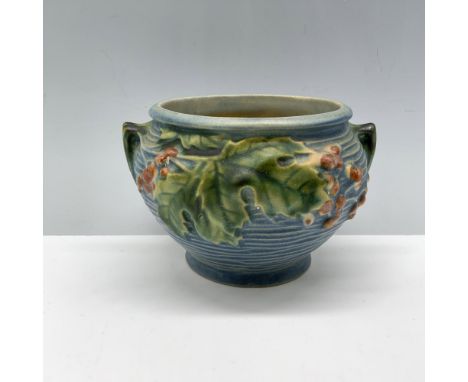 Ravishing decorative planter designed with large leaves and adorned with ridges as well as two small handles. Roseville backs