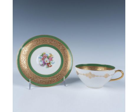 An exquisite two-piece set including a porcelain cup and matching saucer, both elegantly adorned with an ornate gilted floral