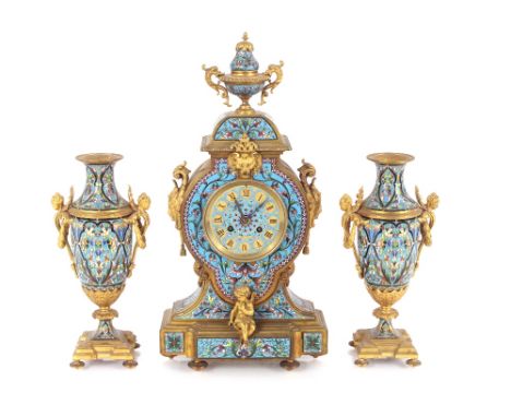 A 19th Century French Ormolu and enamel clock garniture, the clock surmounted by an urn and flanked by foliate masks and scro