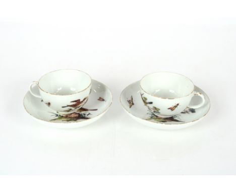 A pair of mid-18th Century Meissen porcelain ornithological cups and saucers, decorated birds on boughs, blur crossed swords 