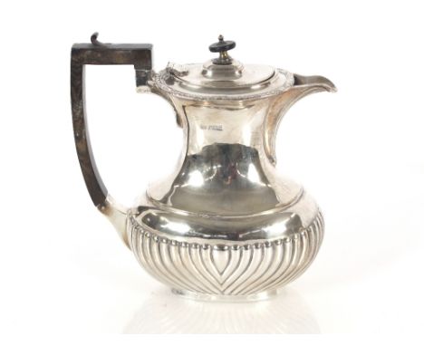 An Edwardian silver teapot with half fluted body decoration, black wood handle and lift; and a matching baluster hot water ju