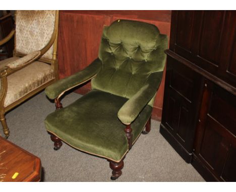 A Victorian mahogany framed deep seated easy chair, upholstered in green Dralon, with curved button back raised on turned fro