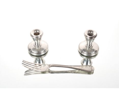 A pair of dwarf silver candlesticks; and a Victorian silver pickle fork,&nbsp;London 1876 (3)