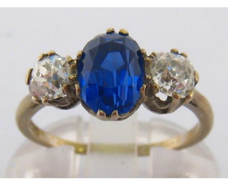 A sapphire and diamond ring, the central oval cut Sri Lankan sapphire (untreated) approx. 1.7 carat, flanked by two cushion c