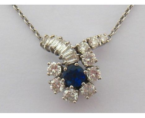 A diamond and synthetic sapphire pendant, the central round cut stone in a surround of brilliants extending out to a branched