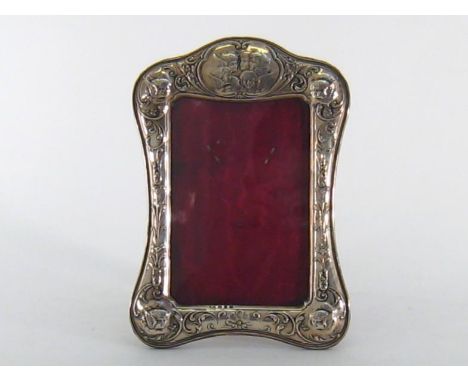 A late Victorian silver photograph frame by William Devenport, Birmingham, 1897, shaped oblong with incurved sides and base, 