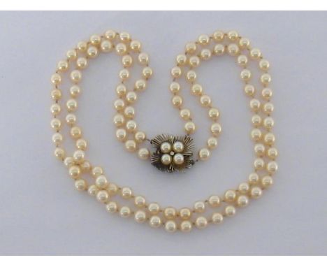 A two strand cultured pearl princess length necklace, composed of uniform 7.2mm pearls, to a four pearl and diamond clasp, st