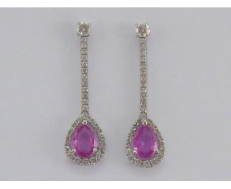 A pair of pink sapphire and diamond earrings, each drop set with a pear cut 7.1 x 5mm pink sapphire in a surround of small br