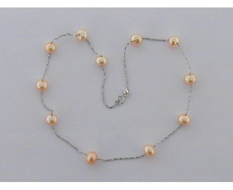 A cultured pearl necklace, set along the chain's length with 11 off-round pearls, the bolt ring clasp stamped 'ITALY 750', 28