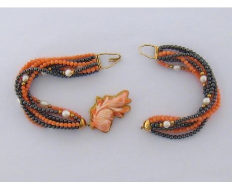 A coral, cultured pearl and haematite choker, the central carved fish motif mounted in gold  stamped '18ct', to a multi-stran