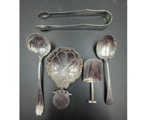 A selection of silver items to include: Sugar shovel, sugar sufter, jam spoon, caddy spoon and sugar tongs. Various hallmarks