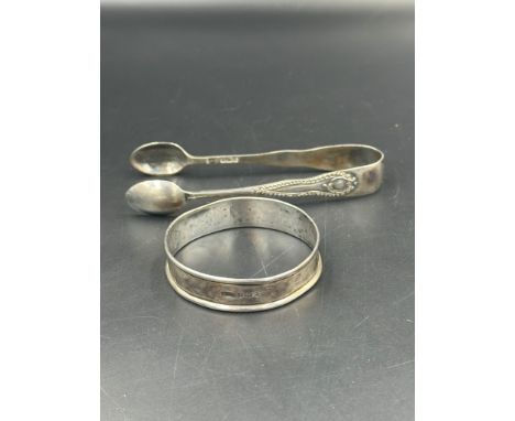 A hallmarked silver bangle and some silver sugar tongs.