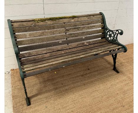 A green cast iron two seater garden bench with wooden slated seat 