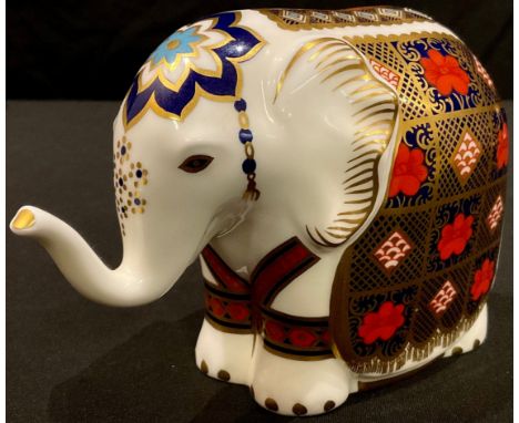 A Royal Crown Derby paperweight, Elephant, printed in the 1128 palette, trunk raised, gold stopper, printed marks in red 