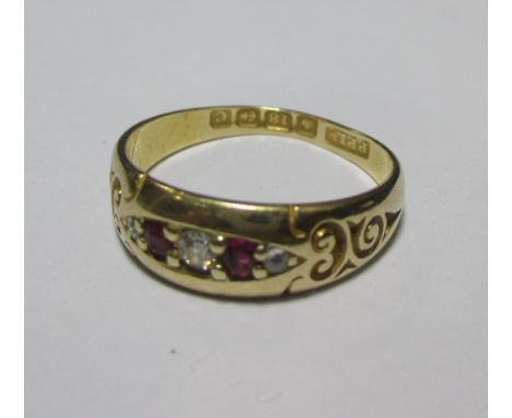 An 18ct ruby and diamond ring, the alternating rubies and diamonds countersunk in a navette form to a broad band with scrolle