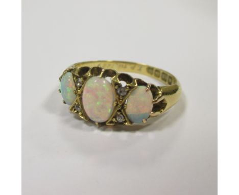 An opal and diamond ring, the three oval opal cabochons set with diamond highlights, all set in 18ct gold, marks worn, late 1