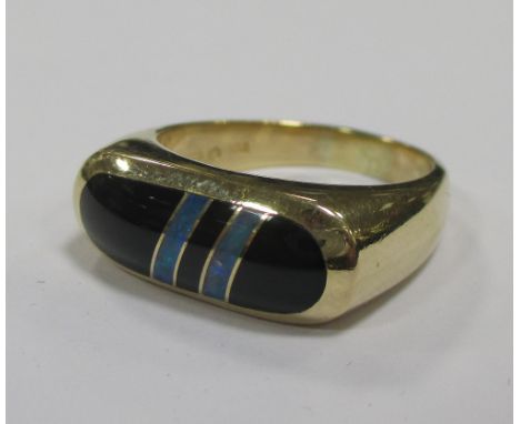 A 14ct gold ring set with two opal bands in a black cabochon  