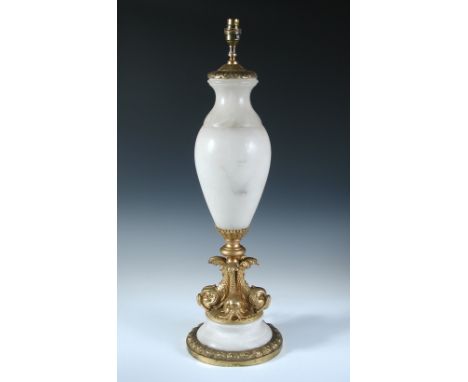 A gilt brass mounted alabaster table lamp, the baluster form raised on four dolphin base and stepped circular foot, 68cm high