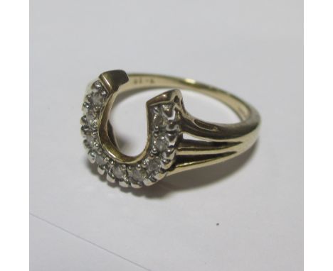 A diamond set horseshoe ring, set to trifurcated shoulders and tapering band, stamped 9ct and 375, size M  