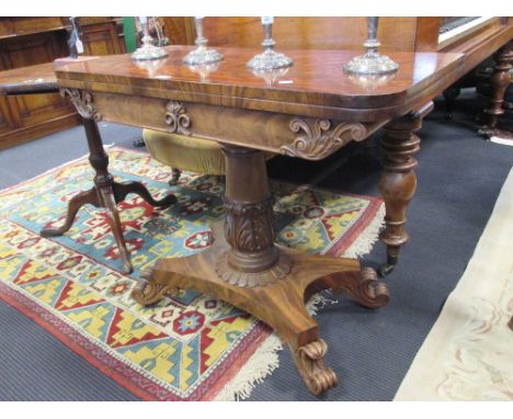 A William IV figured mahogany fold over card table, the frieze and column with heavy acanthus carving, on X-shaped platform a