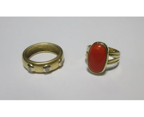 A three stone diamond ring, the small round brilliant diamonds collet set to a wide brushed yellow metal band, stamped 750, s
