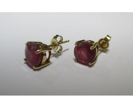 A pair of ruby earstuds, the round rubies, approx. 7.7mm diameter, in a four claw setting with ear posts stamped 750  