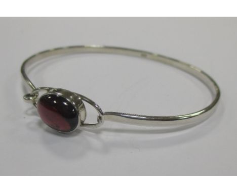A three row pear shaped garnet cabochon and silver necklace, a garnet pendant necklace, a garnet bangle, together with a labr