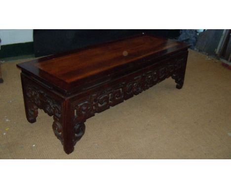 A 19th century Chinese hardwood low table, the rectangular top above pierced and carved scroll apron joining the square secti
