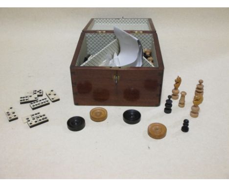 A mahogany box containing chess playing pieces  