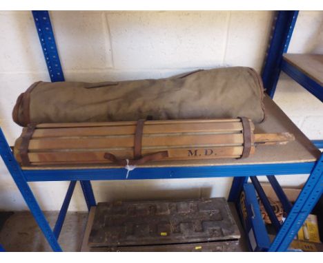 A canvas sleeping bag and army slatted camp bed 