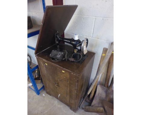 An electric Singer sewing machine - in cabinet (sold as collector's item)