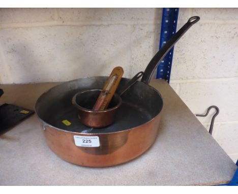 A large copper frying pan; a small copper frying pan; and an old egg timer