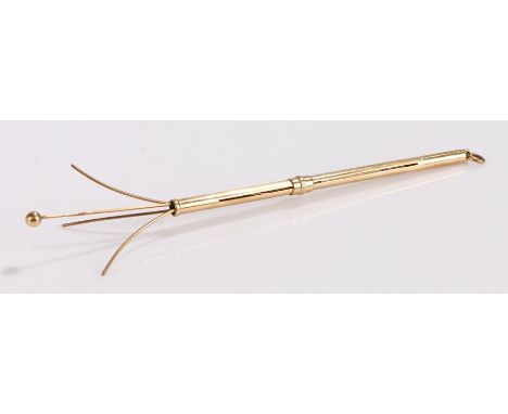 9 carat gold swizzle stick, the slender stock with a sliding collar revealing the swizzle end, 8.5cm long