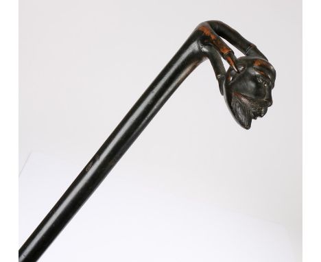 19th Century ebonised walking stick, the handle carved as a claw holding a moustached man's head, 91cm high