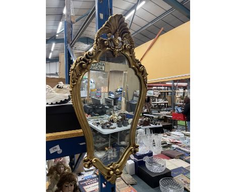 A HEAVY VINTAGE SHIELD SHAPED ORNATE GILT FRAMED MIRROR 81CM X 4CM 