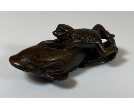 AN ORIENTAL NETSUKE OF A TURTLE MONKEY RIDING A NAMAZU (EARTHQUAKE FISH) SIGNED TO BASE, LENGTH 6.5CM 