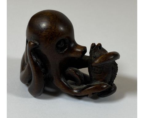AN ORIENTAL NETSUKE OF AN OCTUPUS AND FISH, SIGNED WITH MOTHER OF PEARL MAKERS MARK, HEIGHT 3.5CM 