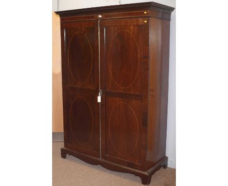 A 19th Century inlaid mahogany wardrobe, with dentil cornice and shell inlaid frieze above a pair of full-length panel doors 