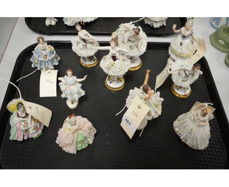 A selection of Dresden and other ceramic figures, each in crinoline lacework style dresses. 