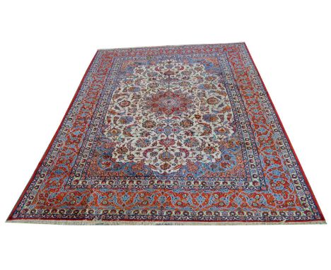 An Isfahan carpet, the central rosette surrounded by floral scrolls, on an ivory-coloured ground, 450 x 326cms.