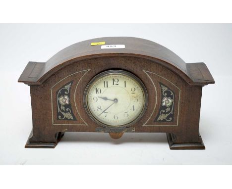 An Arts &amp; Crafts inlaid oak mantle clock, the central white dial with Arabic numerals in black, flanked by mother of pear